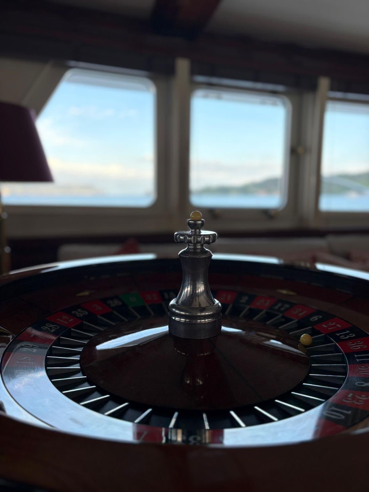 Dettaglio della roulette davanti agli oblò di uno yacht, con il mare sullo sfondo